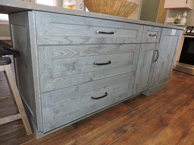 Weathered wood island with brushed hardware in the Alto house