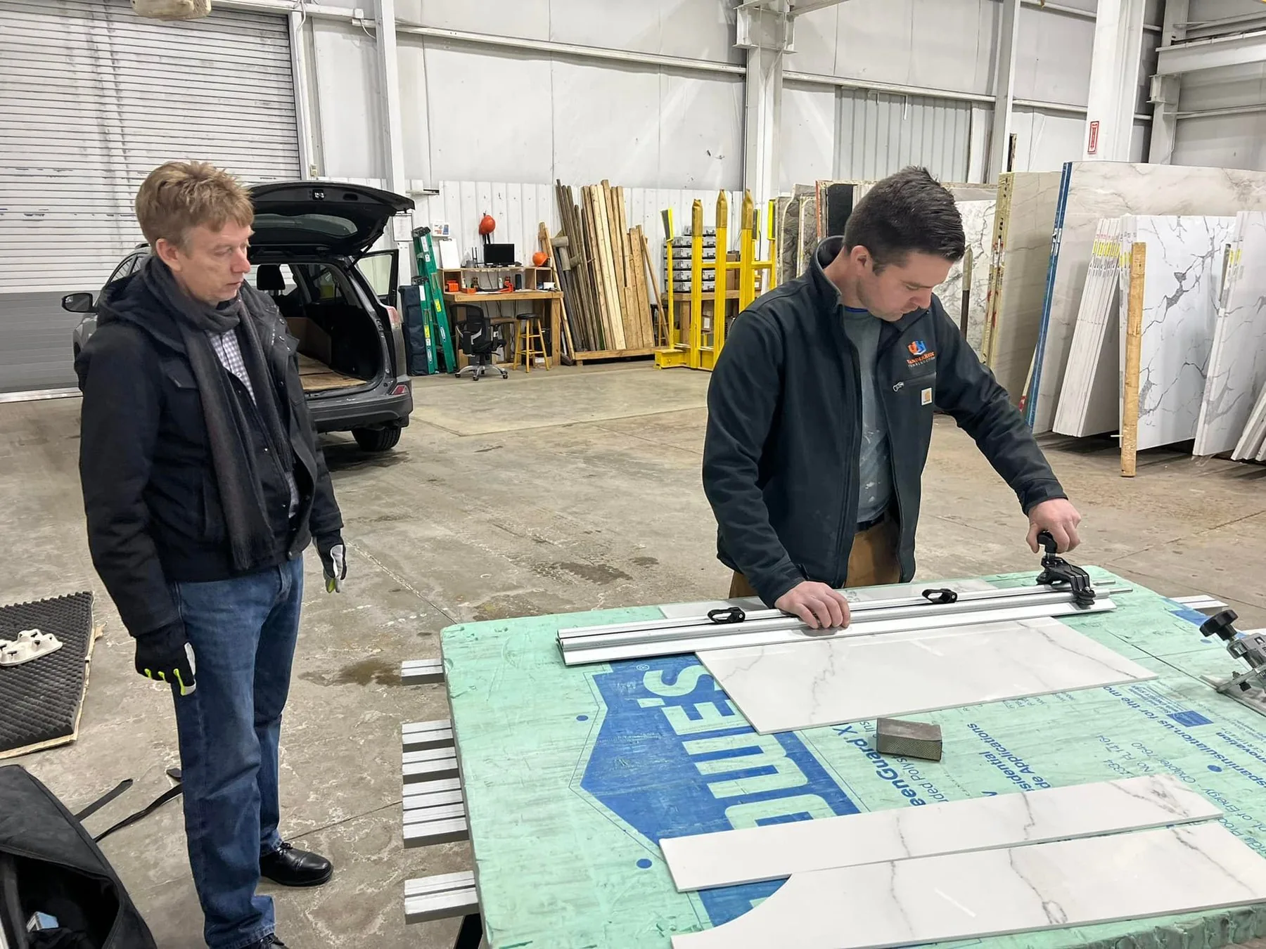 Two team members going over drawings spread across a work table