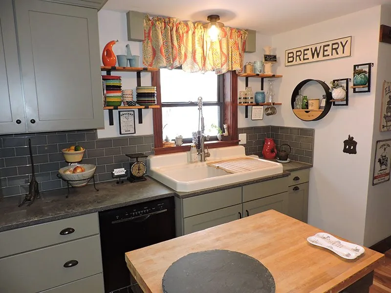 Farmhouse sink and butcher block counter under a window in the Marne kitchen