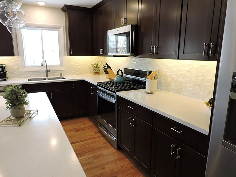 Corner of the Westside Renovation kitchen with a gas range and tile backsplash